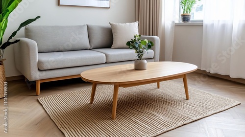 Interior view of a modern living room featuring a gray sofa wooden coffee table and a woven rug. Natural light streams through the window