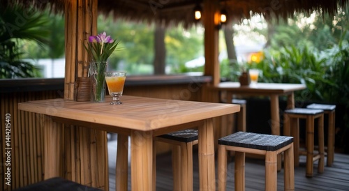 A bamboo gazebo hosts wooden tables and stools set with drinks and flowers blurred backdrop  Warm lighting adds an inviting outdoor dining atmosphere
