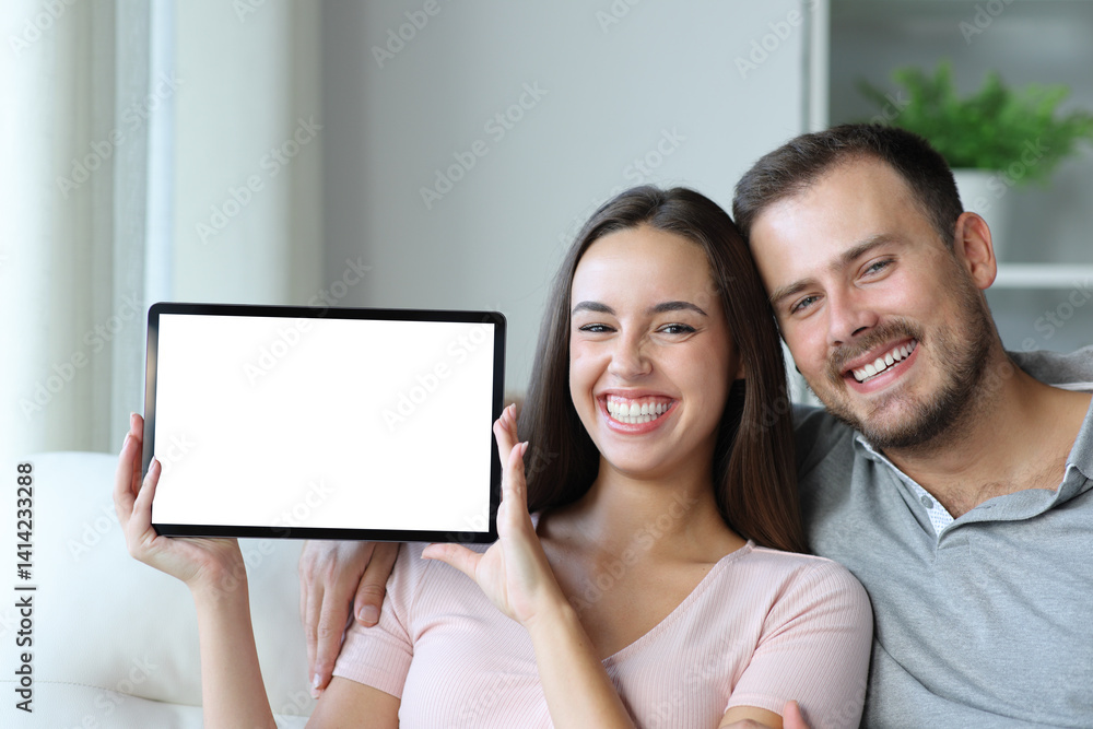 Happy couple showing blank digital tablet screen at home Happy couple showing blank digital tablet screen at home