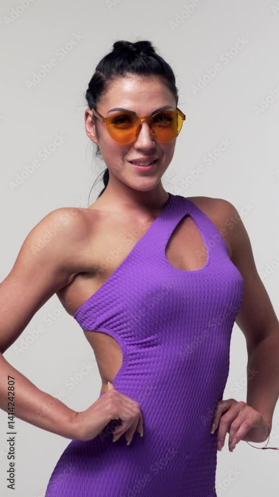 Portrait of a playful and positive woman in purple activewear on a white background, emphasizing individuality. Energy and confidence. Vertical video. Portrait of a playful and positive woman in purple activewear on a white background, emphasizing individuality. Energy and confidence. Vertical video.