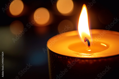 Single candle burning at night with soft flame and warm glow. Serene and peaceful atmosphere, symbolizing light, warmth, and memorial reflection