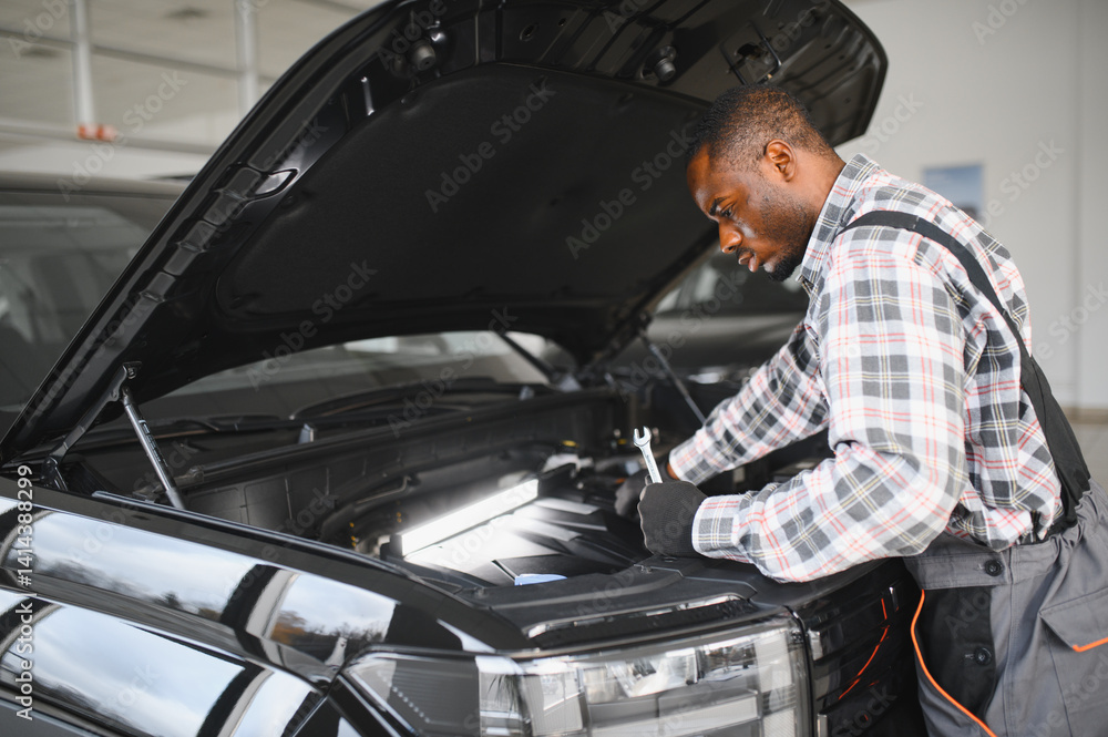 Skilled mechanic technician working at service station, repairing car Skilled mechanic technician working at service station, repairing car