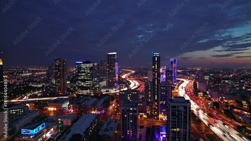 Aerial night view of illuminated cityscape with vibrant highway light trails, dynamic urban landscape showing transportation network and modern skyscrapers Aerial night view of illuminated cityscape with vibrant highway light trails, dynamic urban landscape showing transportation network and modern skyscrapers