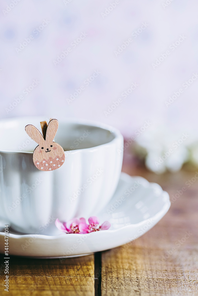 Décor aux couleurs douces pastel rose avec une tasse de thé et un petit lapin de pâques adorable