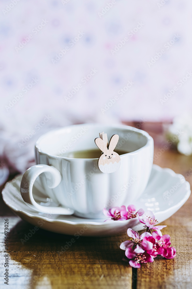 Décor aux couleurs douces pastel rose avec une tasse de thé et un petit lapin de pâques adorable