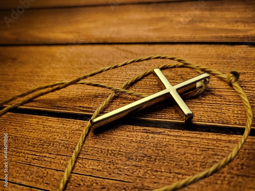 Metal Christian Cross Pendant on Wooden Table – Faith and Spiritual Symbol