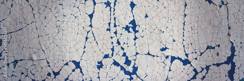 Obraz na płótnie Peeling paint on the wall. Panorama of a concrete wall with old cracked flaking paint. Weathered rough painted surface with patterns of cracks and peeling. Wide panoramic texture for grunge background w salonie