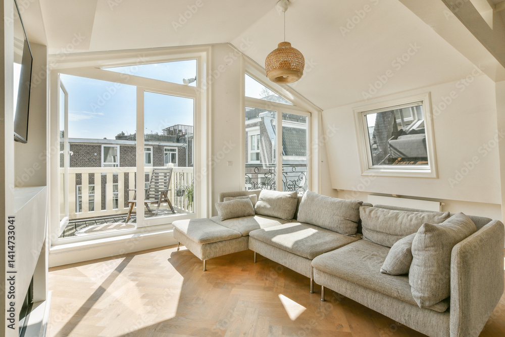 Fototapeta premium A contemporary living space featuring a cozy sofa, ample natural light from large windows, and a stylish design that invites relaxation and comfort.