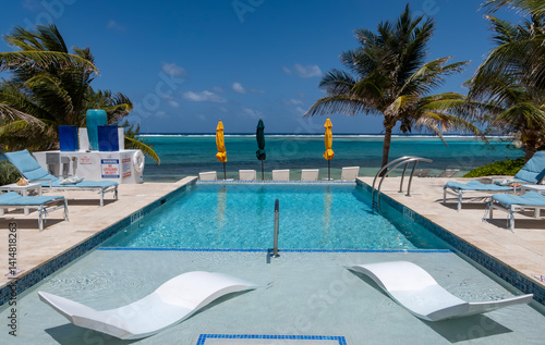 Obraz na płótnie A Beachfront Swimming Pool with a View of the Caribbean Sea and Swaying Palm Trees w salonie
