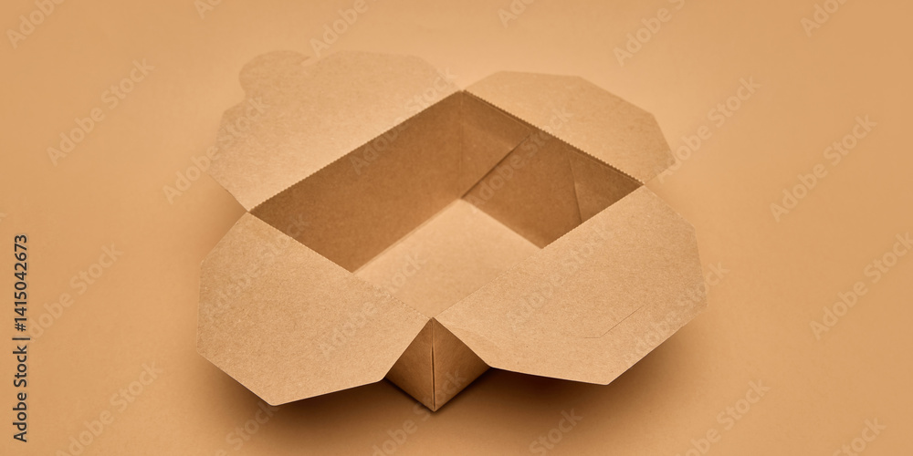 Open cardboard food box with flaps unfolded against light brown background. Sustainable takeaway solutions. Eco-friendly packaging, food delivery, environmental care, restaurant delivery ads concept
