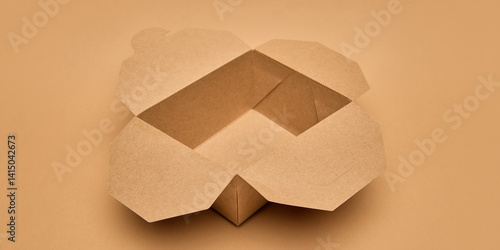 Obraz na płótnie Open cardboard food box with flaps unfolded against light brown background. Sustainable takeaway solutions. Eco-friendly packaging, food delivery, environmental care, restaurant delivery ads concept w salonie