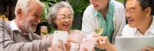Obraz na płótnie Group of older adults enjoying technology together, smiling and sharing moments. Diverse seniors with smartphones and tablets, engaging and connecting happily. Diverse seniors on social media. w salonie