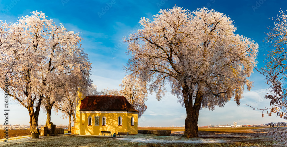 The famous Sebastiani church with frozen trees on a sunny winter day at Wallersdorf, Dingolfing-Landau, Bavaria, Germany