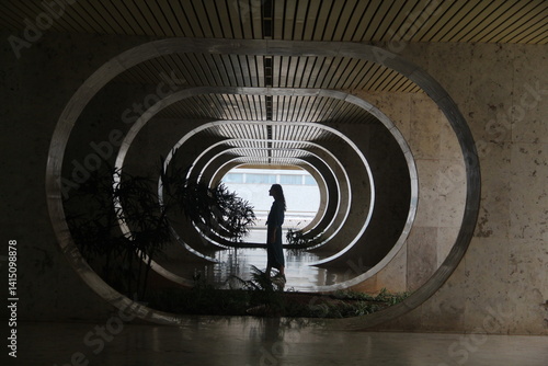 silhuata de mulher entre pilotis de prédio residencial em brasilia