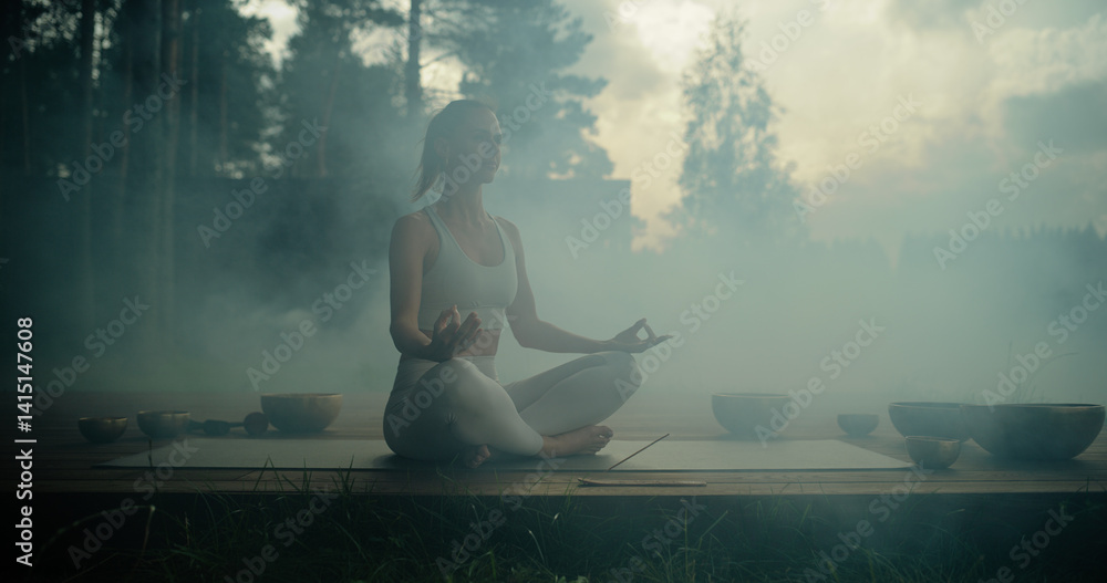 Fototapeta premium Female Yogi Performing a Spiritual Ritual with Smoke, Incenses and Singing Bowls, Cleansing Her Body and Soul, Doing Mindfulness Meditation and Breathing Exercises Outdoors in a Tranquil Forest