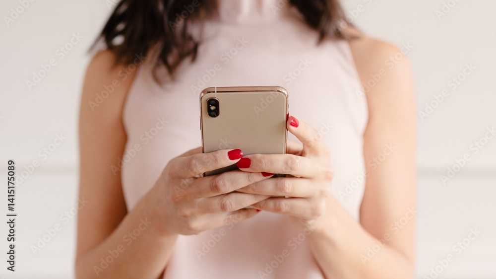 Woman with red nails holding a smartphone. Close-up of hands with smartphone. Focus on smartphone and hands. Casual attire, smartphone use. Woman using social media. Woman with red nails holding a smartphone. Close-up of hands with smartphone. Focus on smartphone and hands. Casual attire, smartphone use. Woman using social media.