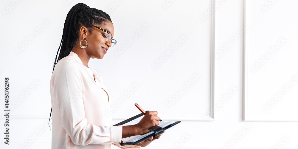 African American woman writing on a tablet in the office. African American business woman workingin with tablet in the white minimal office, African American woman writing, businesswoman in the office