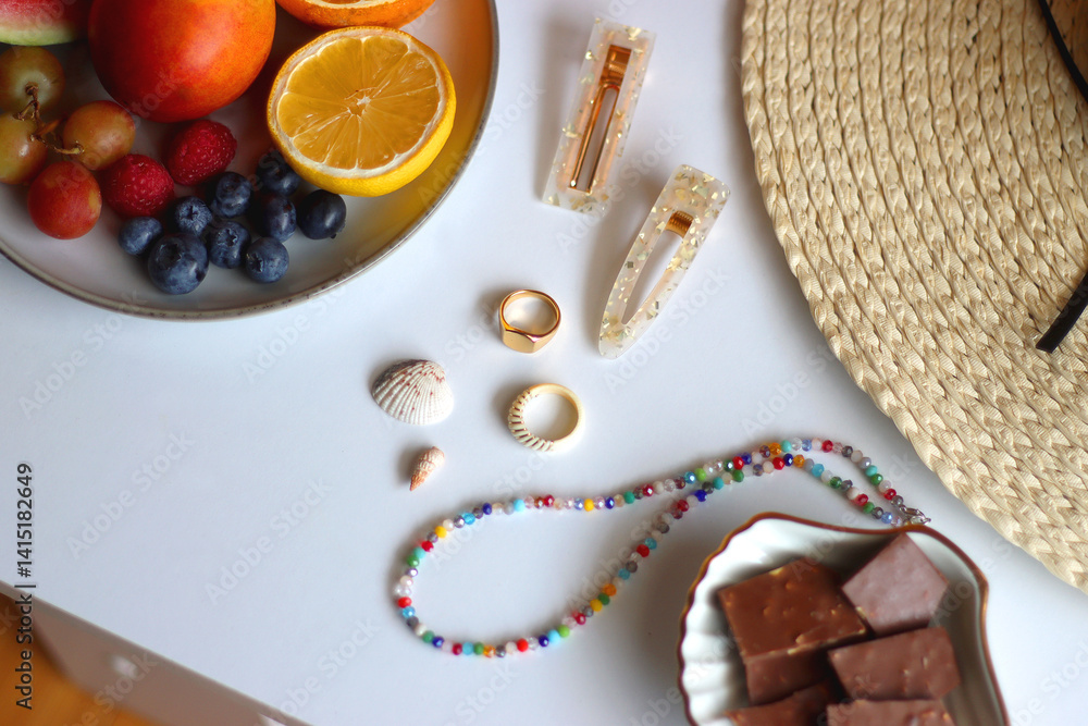 Glass of cocktail, straw hat, sunglasses, books, fresh fruit, chocolate and accessories. Summer essentials on the table. Selective focus.