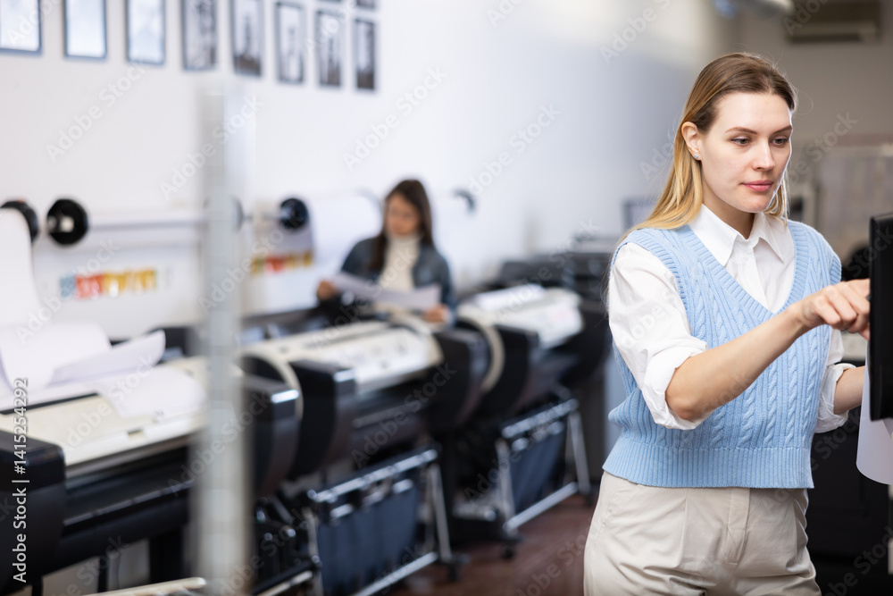 Technician female operator calibrating plotter machine, typing on computer keyboard Technician female operator calibrating plotter machine, typing on computer keyboard