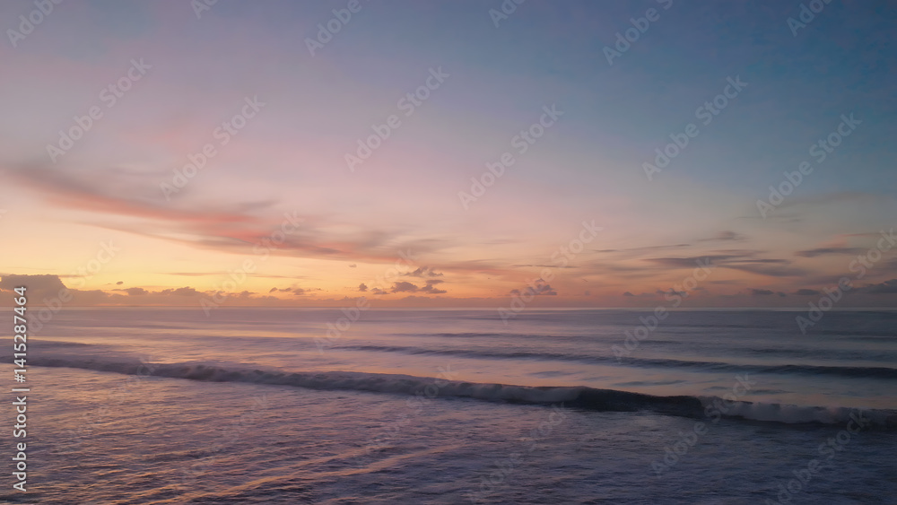 Fototapeta premium Pastel Sunset Hues Over Gentle Ocean Waves