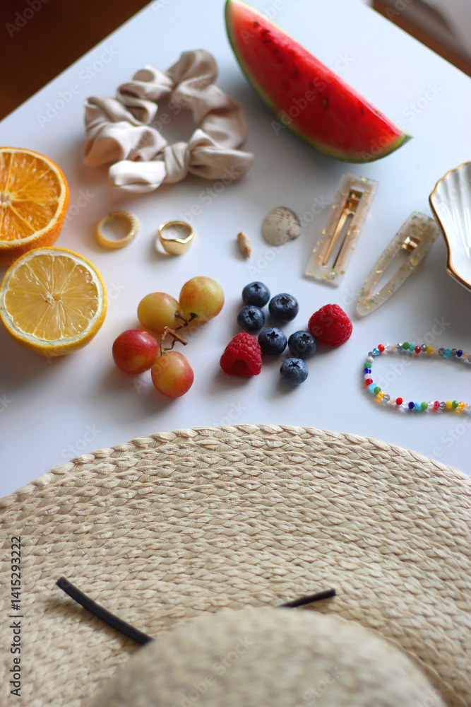 Straw hat, sunglasses, seasonal fruit, seashells and colorful accessories on white backgrounds. Cute summer essentials. Selective focus.