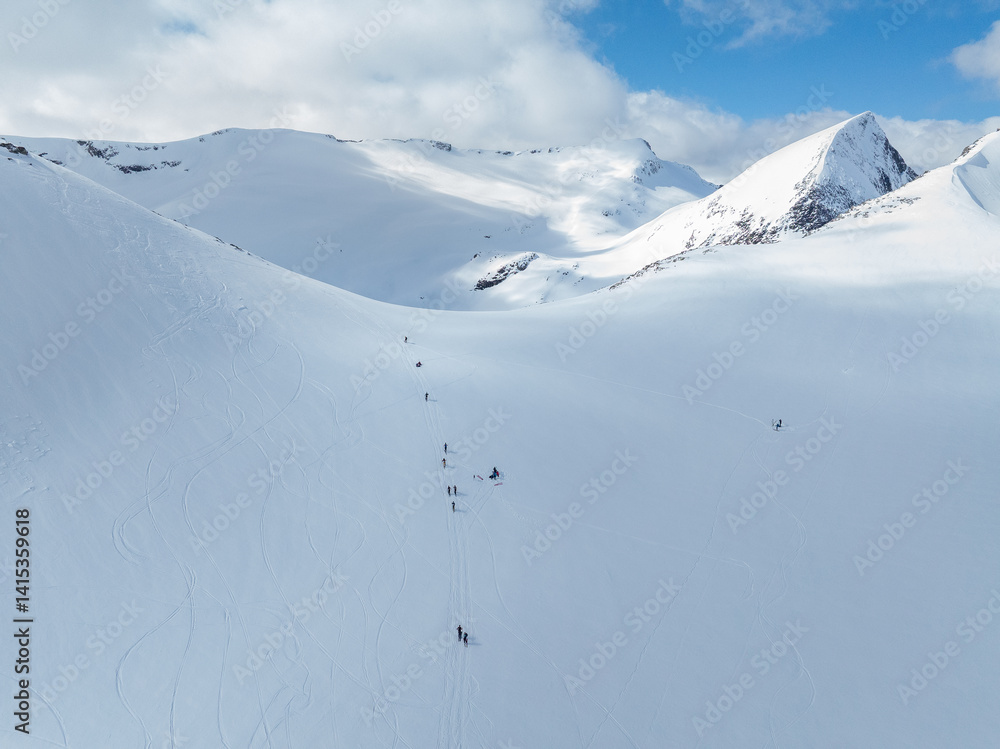Alpine skiers on their way up to the top, and some skiers on their way down. Norwegian winter mountain landscape. Alpine skiers on their way up to the top, and some skiers on their way down. Norwegian winter mountain landscape.