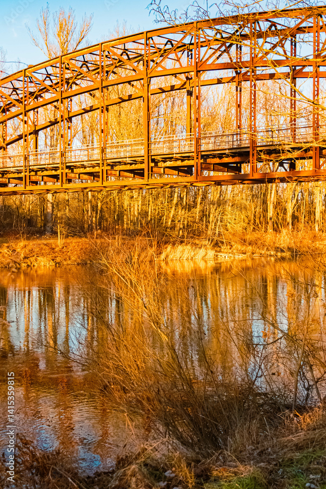 Winter landscape with an old railway bridge and reflections on a sunny evening near Landau an der Isar, Dingolfing-Landau, Bavaria, Germany