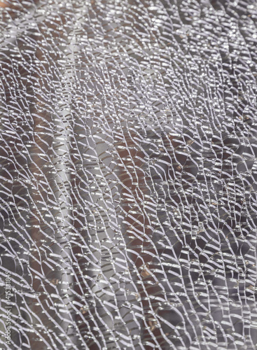 Obraz na płótnie Detail of broken tempered glass pane too many small irregular shape pieces holding together. Texture of cracked broken glass cracked by impact, Cracks on the glass surface background, Space for text. w salonie