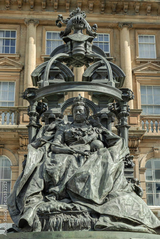 Extravagant bronze statue of Queen Victoria in St. Nicholas' Square. The figure of the elderly Queen Victoria is seated on the throne with an elaborate canopy on a Pink granite base is by the sculptor