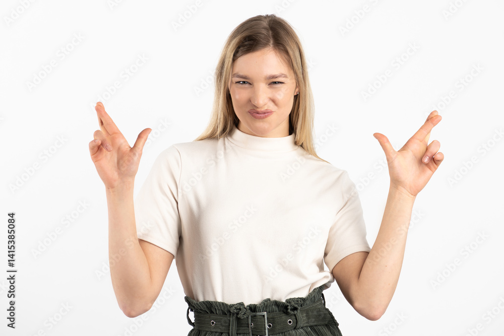 Studio portrait of beautiful smiling and happy woman with crossed fingers. Model looking at camera and wearing white blouse and khaki shorts. White studio background with copy space Studio portrait of beautiful smiling and happy woman with crossed fingers. Model looking at camera and wearing white blouse and khaki shorts. White studio background with copy space