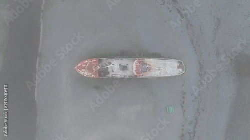 Aerial top-down view of the rusted Gardar BA 64 shipwreck beached on the black sands of Iceland, surrounded by muted textures and natural tones.