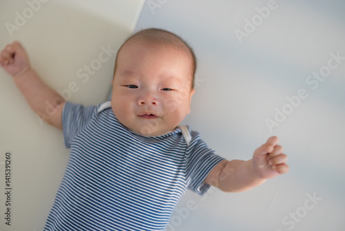 Obraz na płótnie Newborn baby with blue outfit lying on bed w salonie