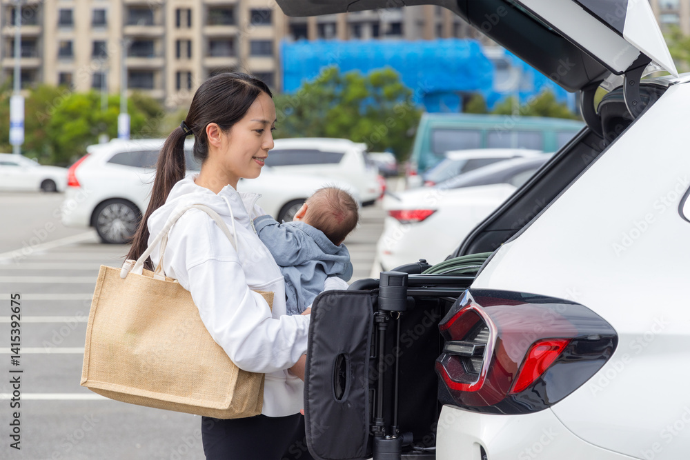 Mother taking baby stroller out of car
