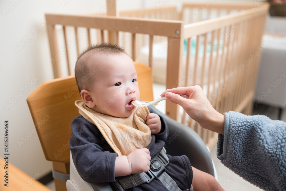 Mother Feeding Her Baby With Spoon At Home