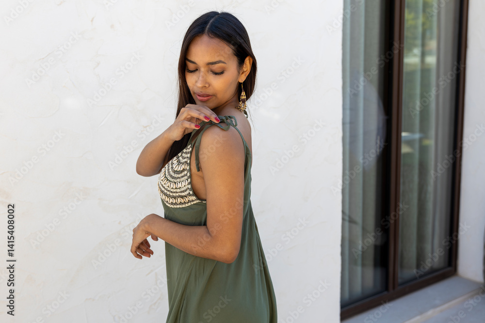 Fototapeta premium Brunette girl posing wearing dress on a white wall. 