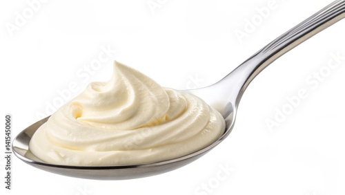 Obraz na płótnie A spoon holds a generous dollop of whipped topping, showcasing its creamy texture. The setting hints at a kitchen environment with bright lighting, ideal for culinary creations w salonie