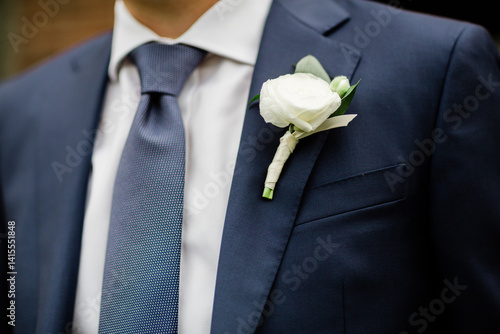 groom in a blue suit and boutonnière 