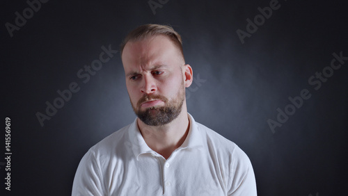 A man in a white shirt displays a frown, conveying frustration or dissatisfaction. The close-up shot intensifies his emotions.