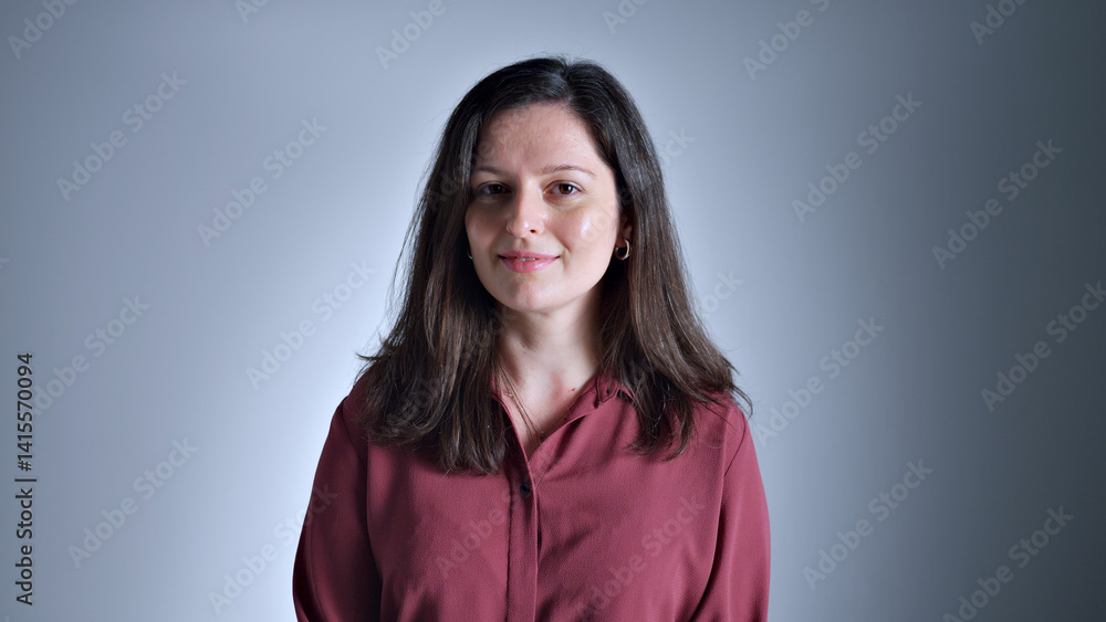A woman in a red shirt poses confidently, exuding self-assurance and poise. The close-up shot accentuates her expression and attire. A woman in a red shirt poses confidently, exuding self-assurance and poise. The close-up shot accentuates her expression and attire.