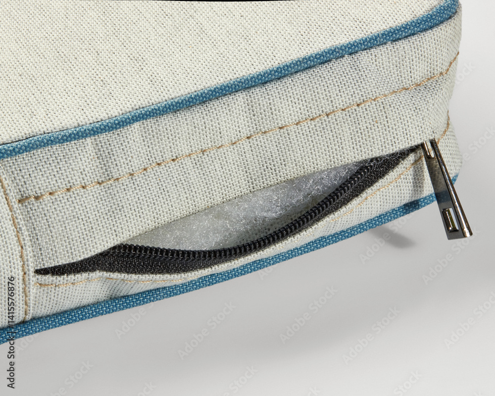 Close-up of zipper on outdoor cushion revealing foam filling
