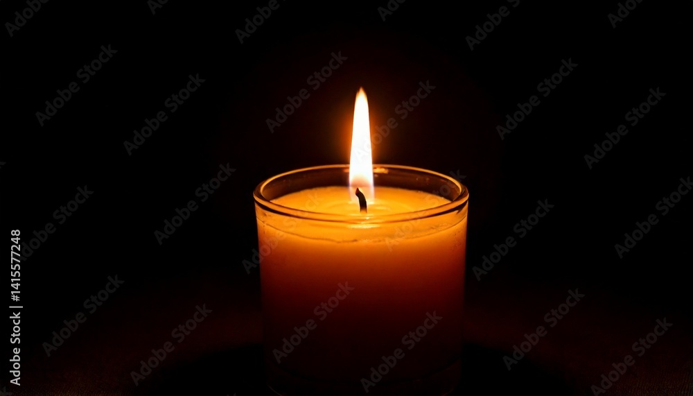 One candle burning slowly isolated on pitch black background One candle burning slowly isolated on pitch black background