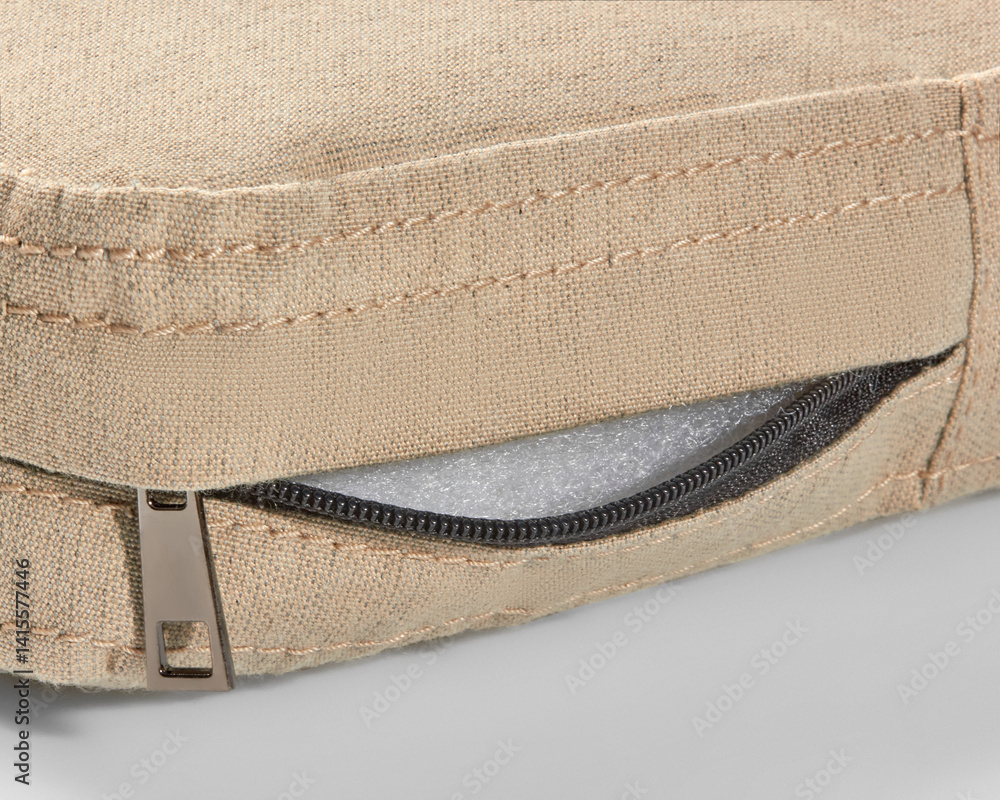 Open zipper showing foam filling of beige fabric cushion