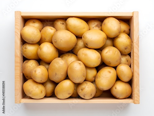Top view perspective of fresh raw yellow potatoes completely filling a rustic wooden crate on white background.