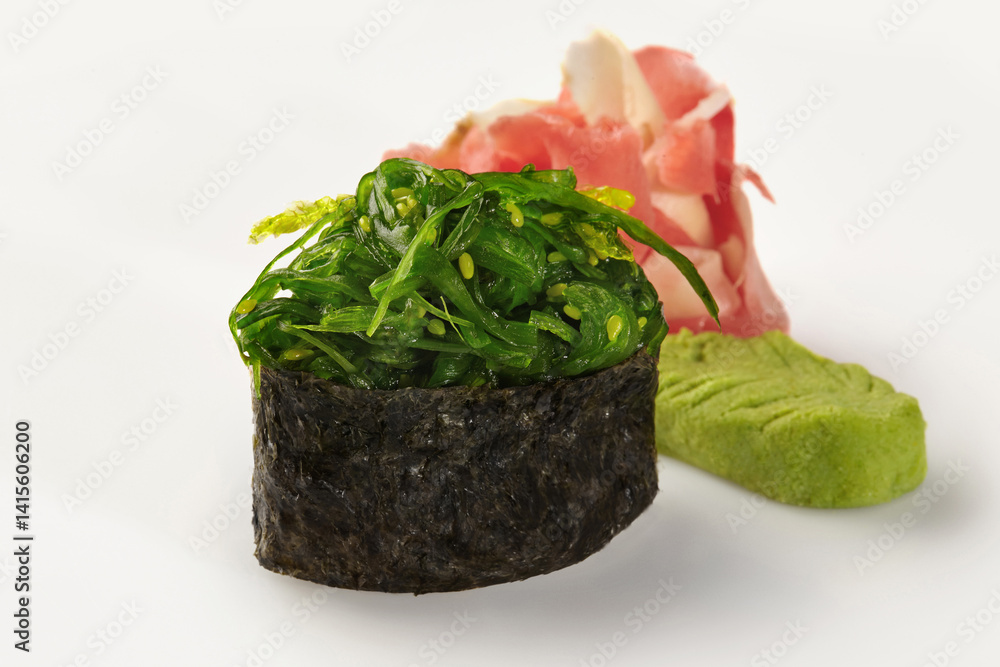 Gunkan maki sushi with chukka seaweed, pickled ginger and wasabi on white background