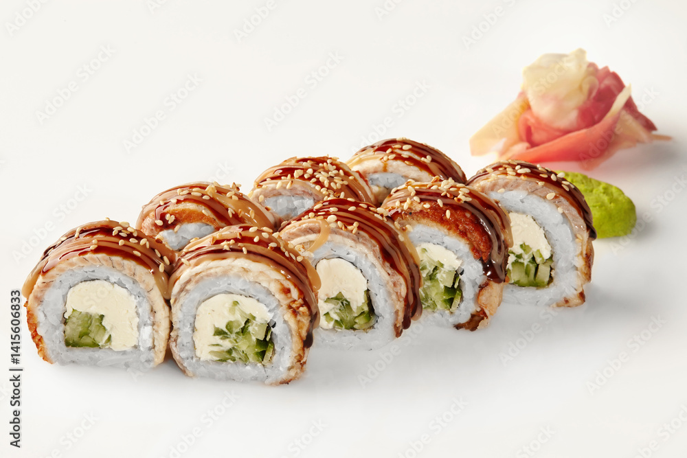 Delicious sushi rolls with eel, cucumber, cream cheese, sesame seeds, and unagi sauce on white background