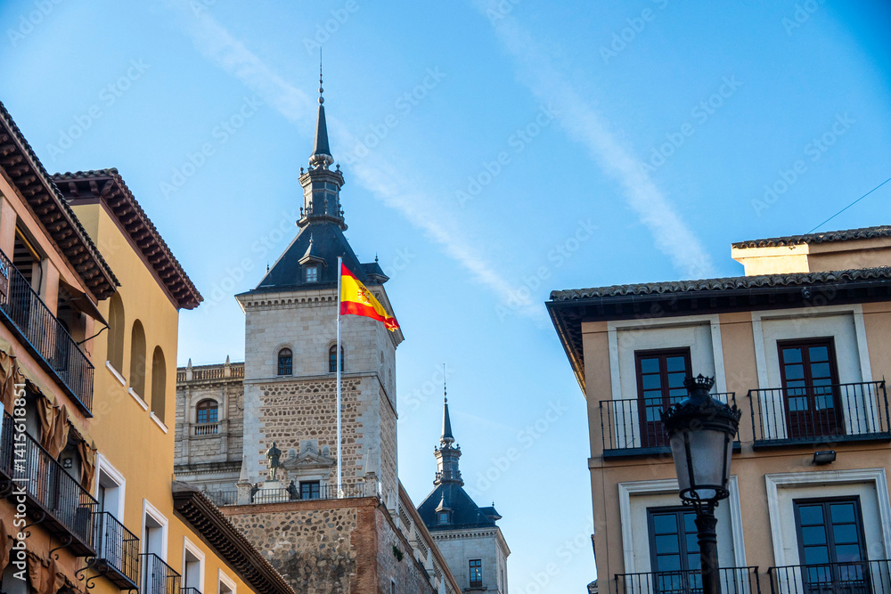 Naklejka premium A vibrant Spanish flag waves in the wind against a blue sky
