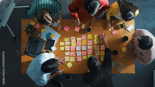 Obraz na płótnie Top view of smart diverse business team working together and clapping hand while brainstorming marketing idea or creative startup project by using sticky notes and stick at meeting table. Convocation. w salonie