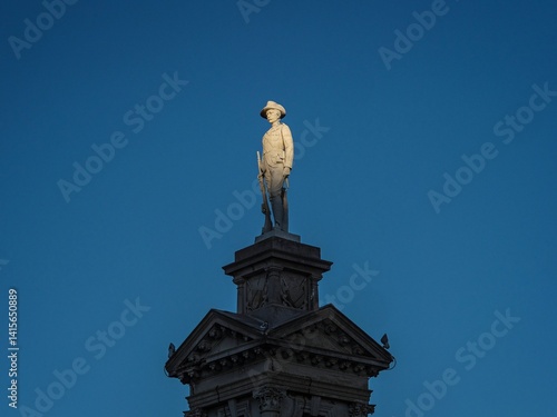 Soldier statue sculpture illuminated by the sun on top of Troopers South Africa Boer War Memorial in Invercargill Southland South Island New Zealand