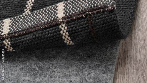 Modern area rug rolled on soft underlay showcasing texture and design in a cozy interior setting.