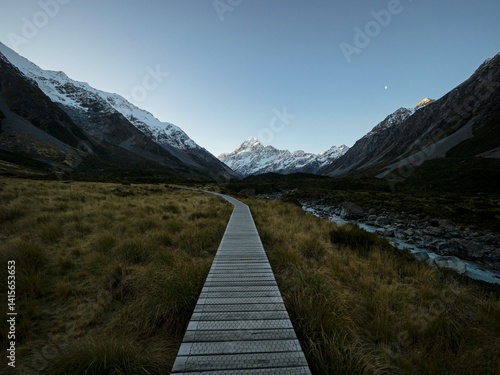Wooden walkway boardwalk hiking trail path leading to alpine snow covered Southern Alps mountains, Hooker Valley Track, Aoraki Mount Cook New Zealand